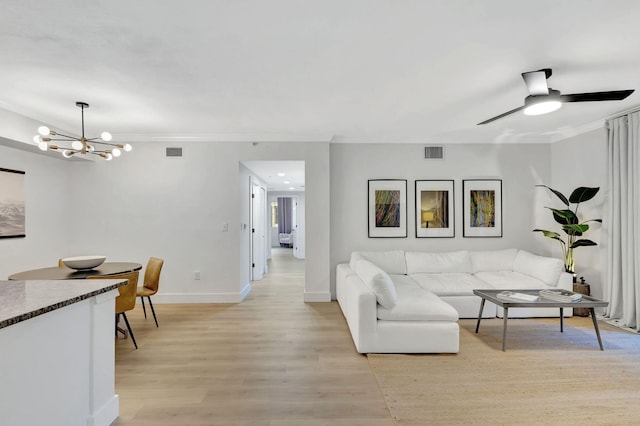 living room featuring light wood-type flooring, ceiling fan with notable chandelier, and crown molding