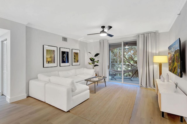 living room featuring ceiling fan, ornamental molding, and light hardwood / wood-style floors