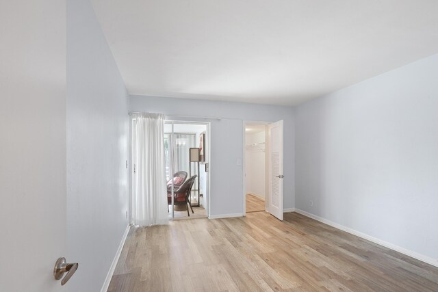 unfurnished bedroom with light hardwood / wood-style flooring and a closet