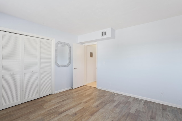 unfurnished bedroom featuring light hardwood / wood-style flooring and a closet