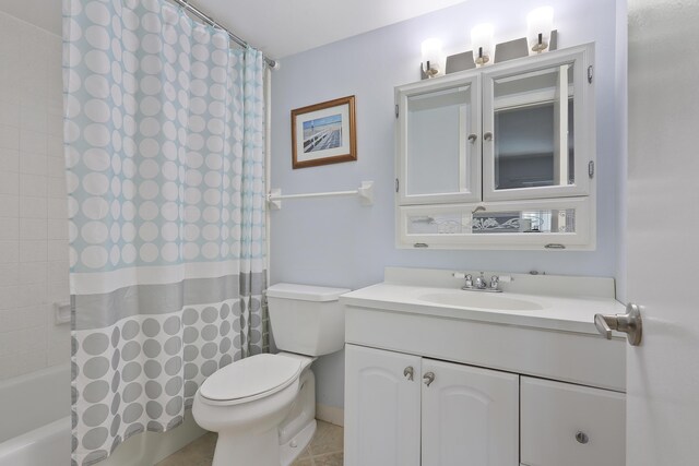 bathroom featuring a tile shower, tile patterned floors, vanity, and toilet