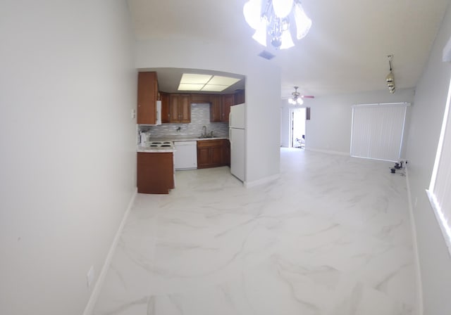 kitchen featuring white appliances, open floor plan, marble finish floor, light countertops, and tasteful backsplash