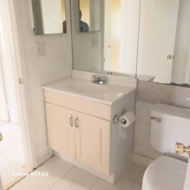 bathroom featuring tile patterned floors, vanity, and toilet