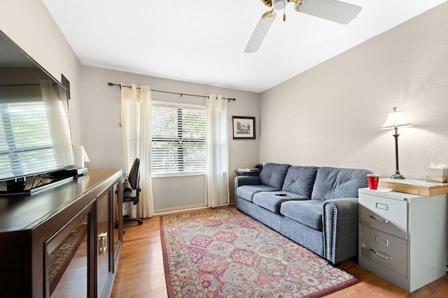 living room featuring light hardwood / wood-style flooring and ceiling fan