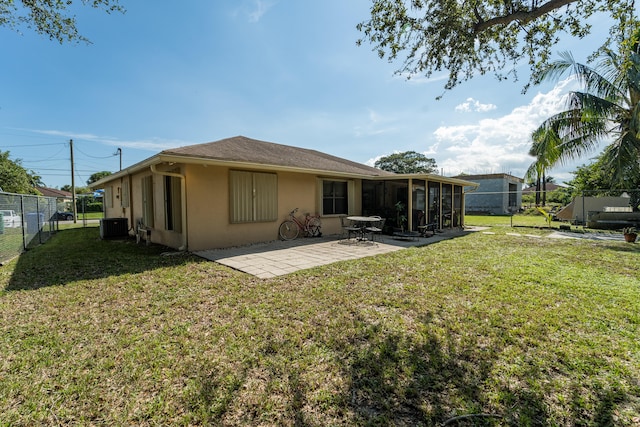 back of house featuring cooling unit, a yard, a sunroom, and a patio area