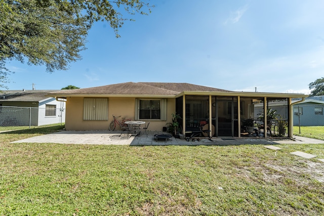 rear view of house featuring a sunroom, a patio area, and a yard