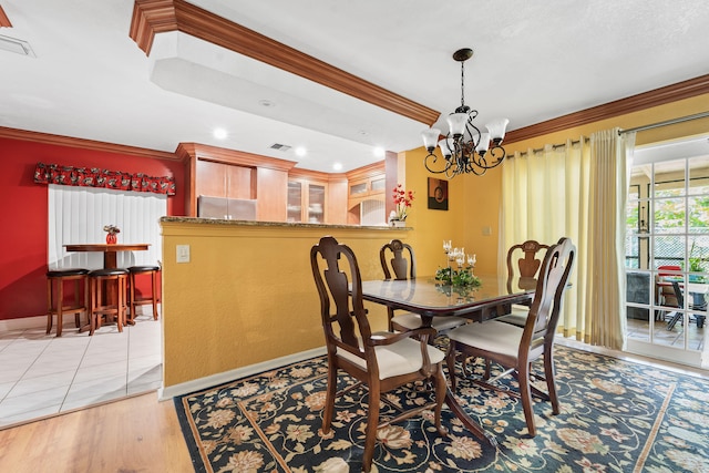 dining space featuring an inviting chandelier, light hardwood / wood-style floors, and crown molding