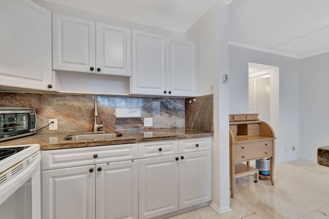 kitchen featuring tasteful backsplash, white cabinetry, and sink