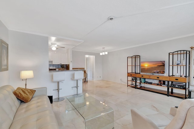 living room with ceiling fan and ornamental molding