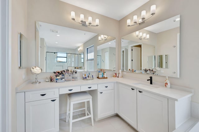 bathroom featuring vanity, an inviting chandelier, walk in shower, and tile patterned floors