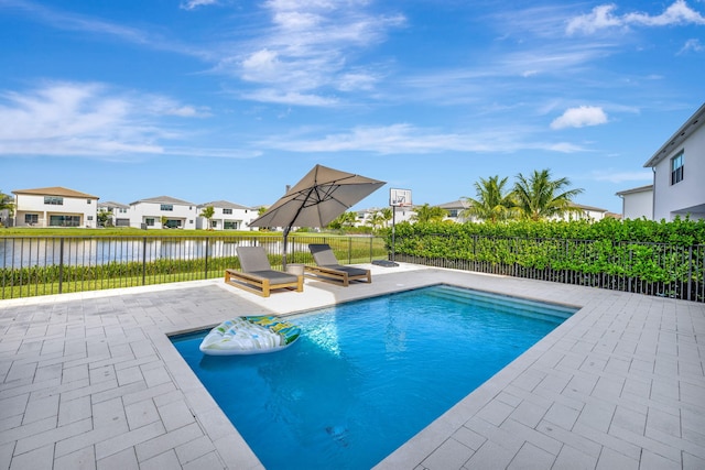 view of pool featuring a patio and a water view