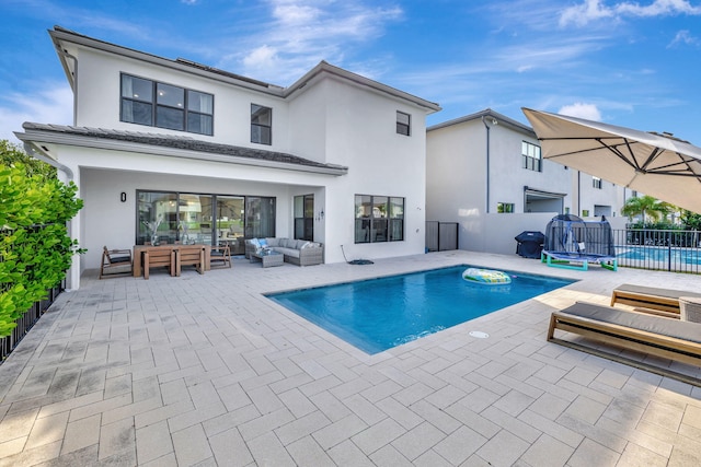 view of swimming pool featuring an outdoor living space and a patio area