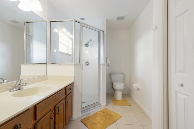 bathroom featuring vanity, toilet, a shower with door, and tile patterned floors