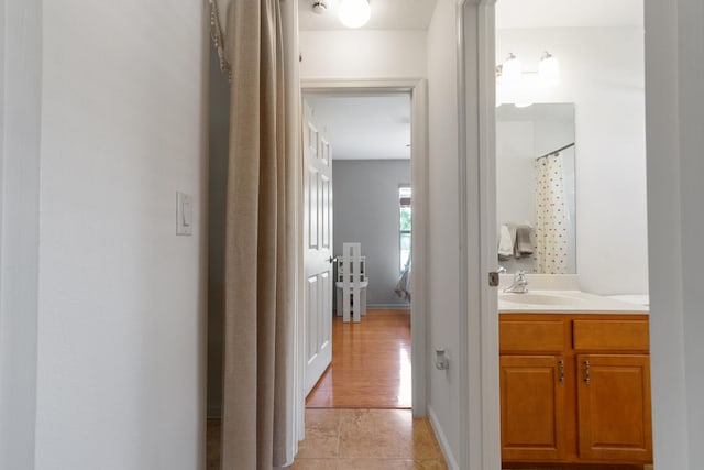 hallway with sink and light hardwood / wood-style flooring