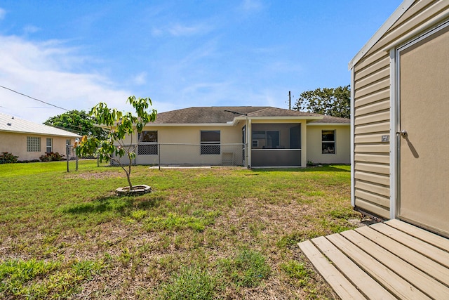 back of property with a sunroom and a yard