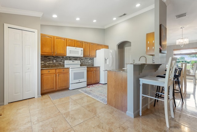 kitchen with a breakfast bar area, stone counters, white appliances, decorative light fixtures, and ornamental molding