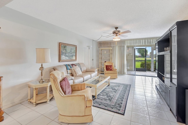 living room with ceiling fan, light tile patterned floors, and a textured ceiling