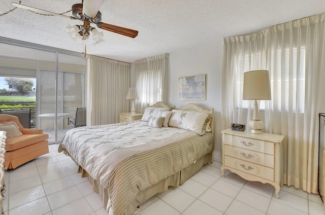 bedroom featuring ceiling fan, tile patterned floors, and a textured ceiling