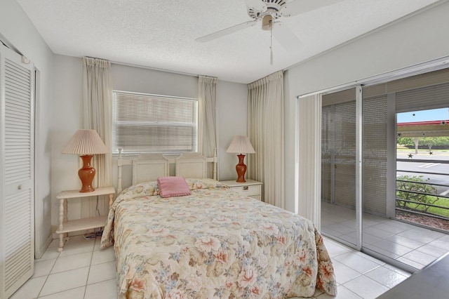 tiled bedroom with ceiling fan, a textured ceiling, and a closet