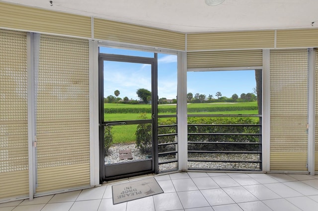 doorway to outside featuring a rural view and light tile patterned flooring