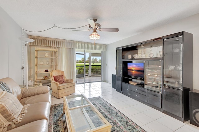 tiled living room featuring ceiling fan and a textured ceiling