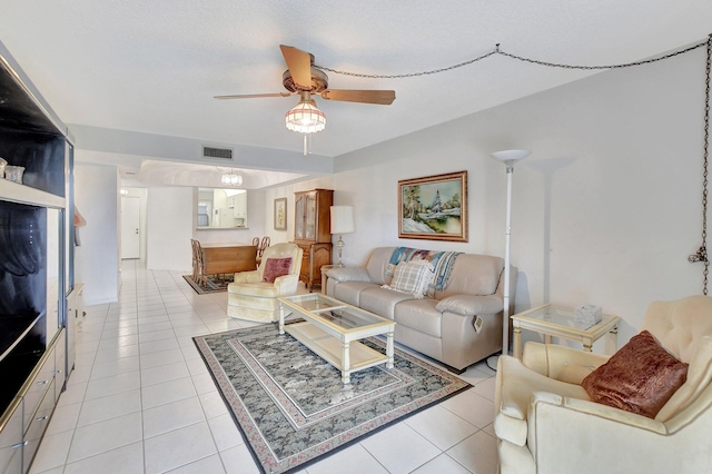 tiled living room featuring ceiling fan and a textured ceiling