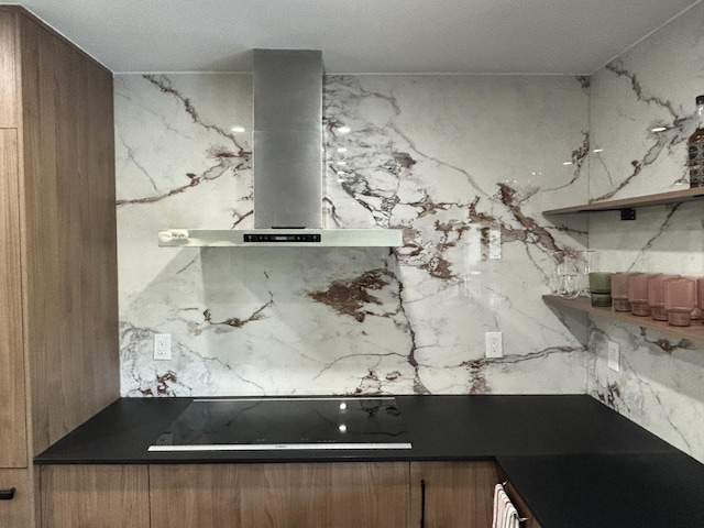 kitchen featuring black stovetop and wall chimney range hood