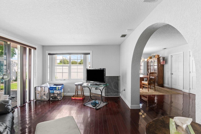 living room featuring a textured ceiling and dark hardwood / wood-style flooring