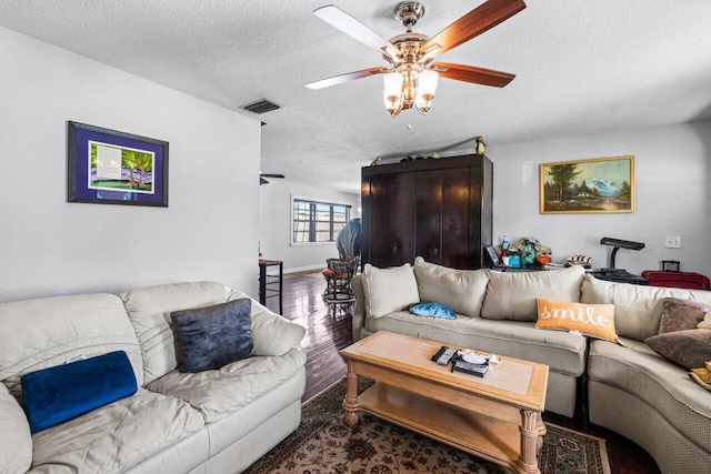 living room featuring a textured ceiling, hardwood / wood-style floors, and ceiling fan