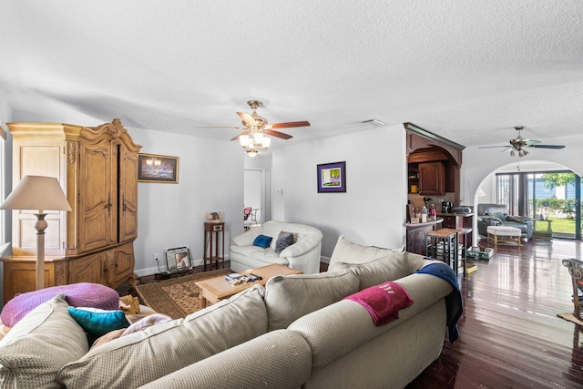 living room with a textured ceiling, hardwood / wood-style floors, and ceiling fan