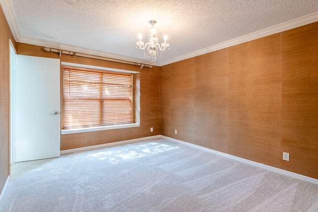 empty room with carpet, crown molding, a textured ceiling, and a chandelier