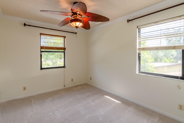 empty room with carpet, crown molding, a textured ceiling, and ceiling fan