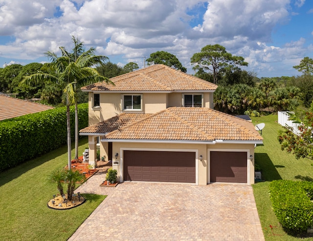 mediterranean / spanish-style house featuring a front yard and a garage