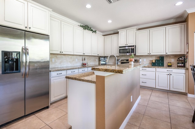 kitchen featuring an island with sink, tasteful backsplash, stainless steel appliances, and white cabinets