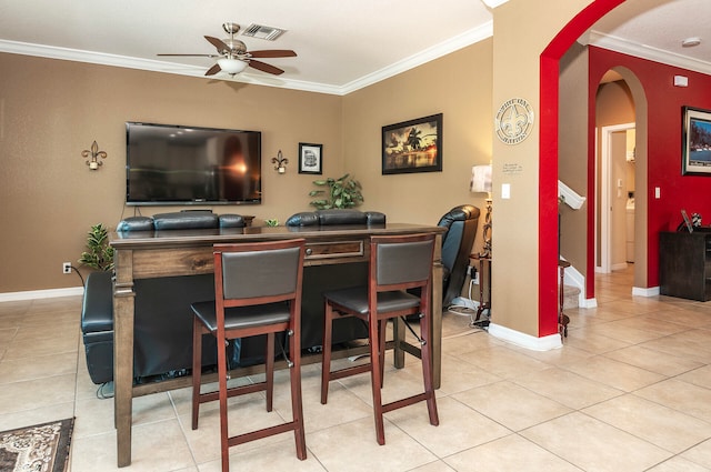 tiled dining space featuring ornamental molding and ceiling fan