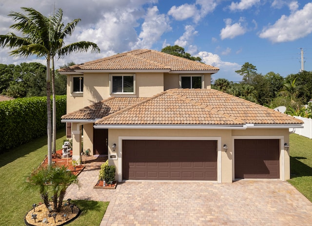 mediterranean / spanish house with a front yard and a garage