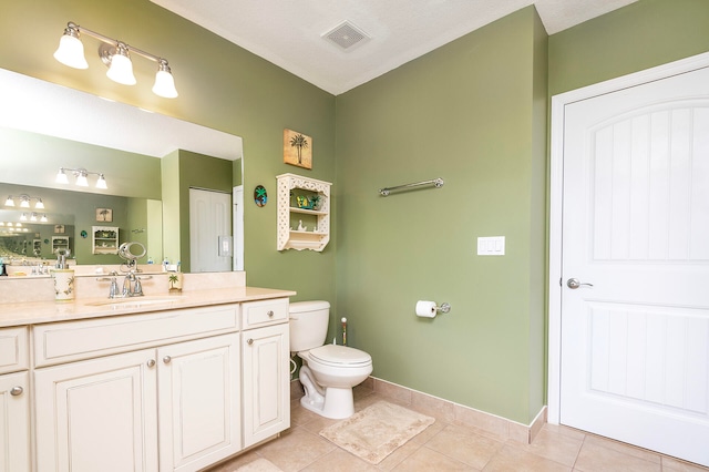 bathroom with vanity, tile patterned flooring, toilet, and a textured ceiling