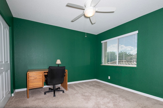 carpeted office space featuring ceiling fan