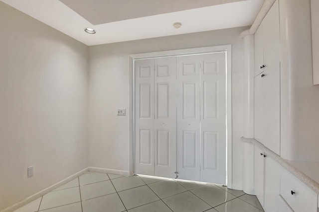 interior space with light tile patterned floors and a closet