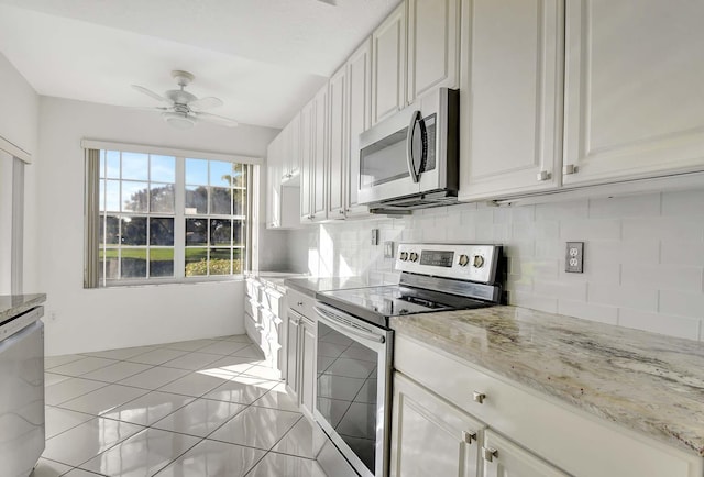 kitchen with tasteful backsplash, white cabinetry, light stone countertops, and stainless steel appliances