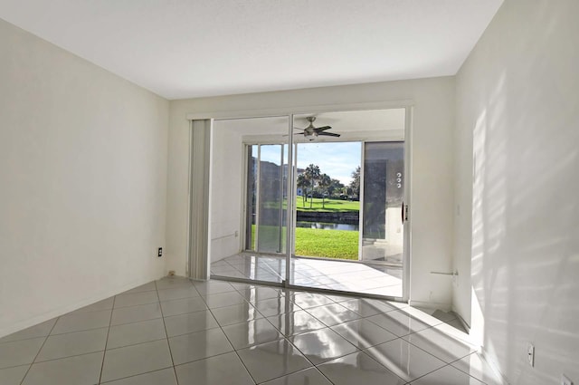 tiled empty room with ceiling fan and a water view