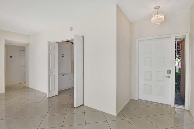 tiled foyer featuring an inviting chandelier