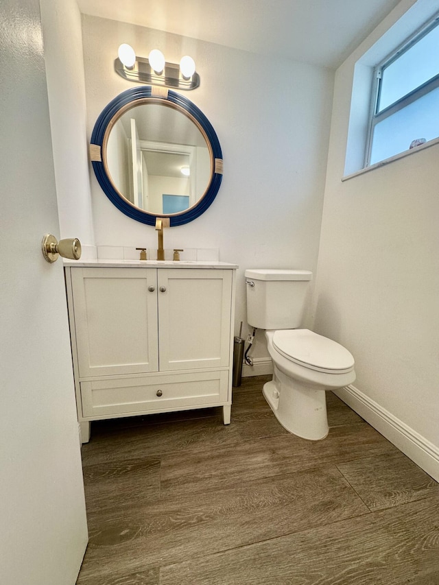 bathroom featuring vanity, wood finished floors, toilet, and baseboards