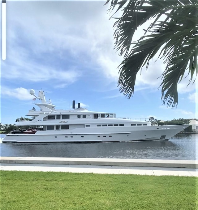 view of dock with a water view and a lawn