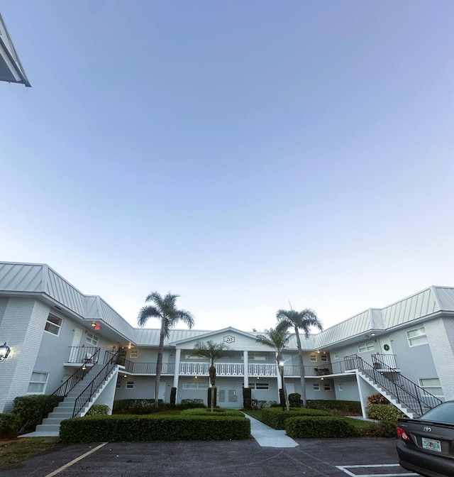 view of property featuring uncovered parking and stairway