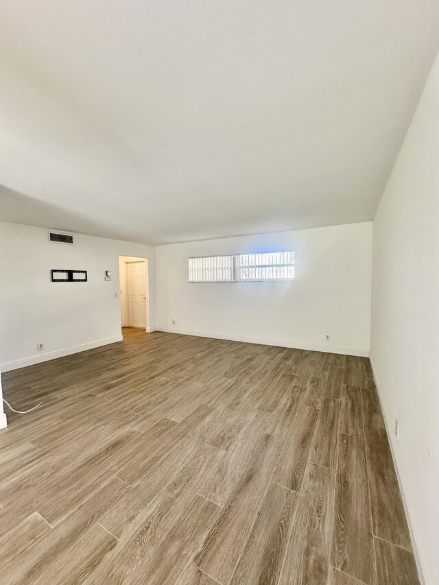 unfurnished living room featuring hardwood / wood-style flooring and plenty of natural light