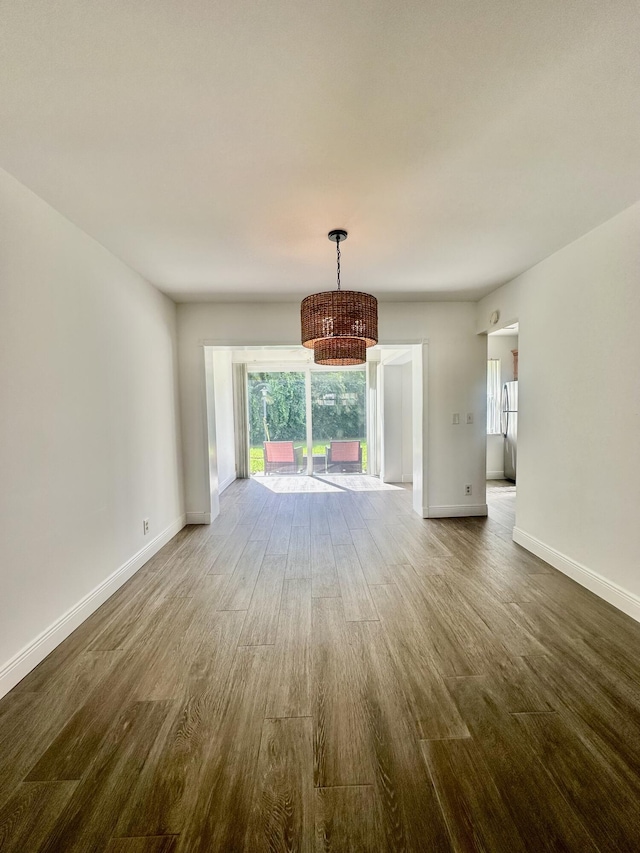 unfurnished living room with baseboards and wood finished floors