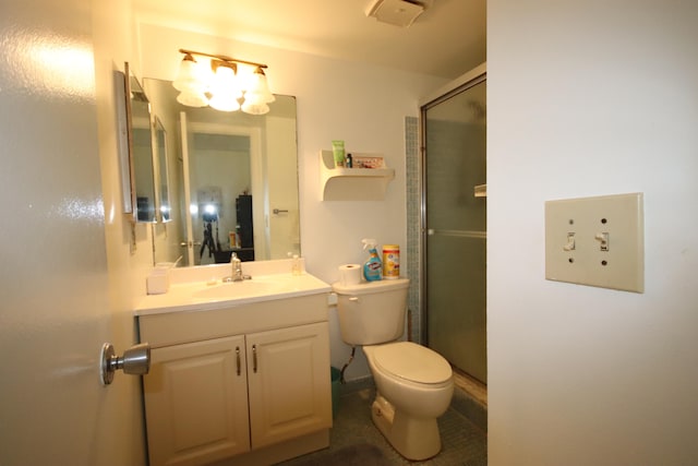 bathroom with vanity, a shower with shower door, and toilet