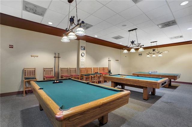 recreation room with dark carpet and a drop ceiling