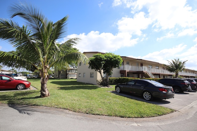 view of front of property with a balcony and a front lawn